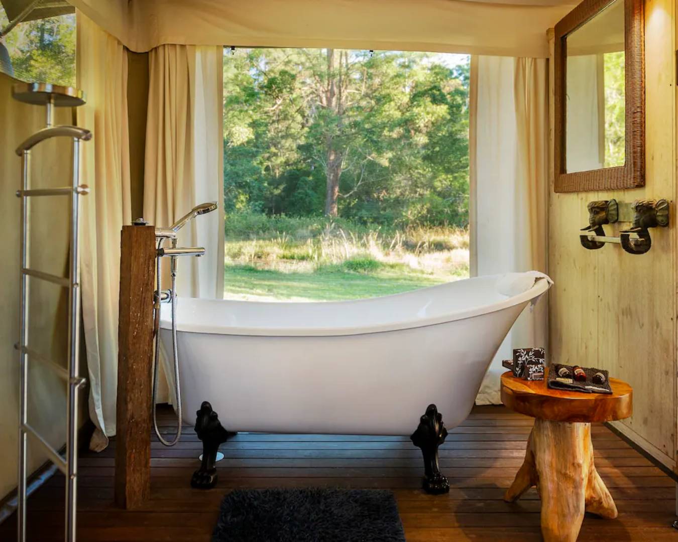 Indoor bathtub overlooking grassy area outside through window