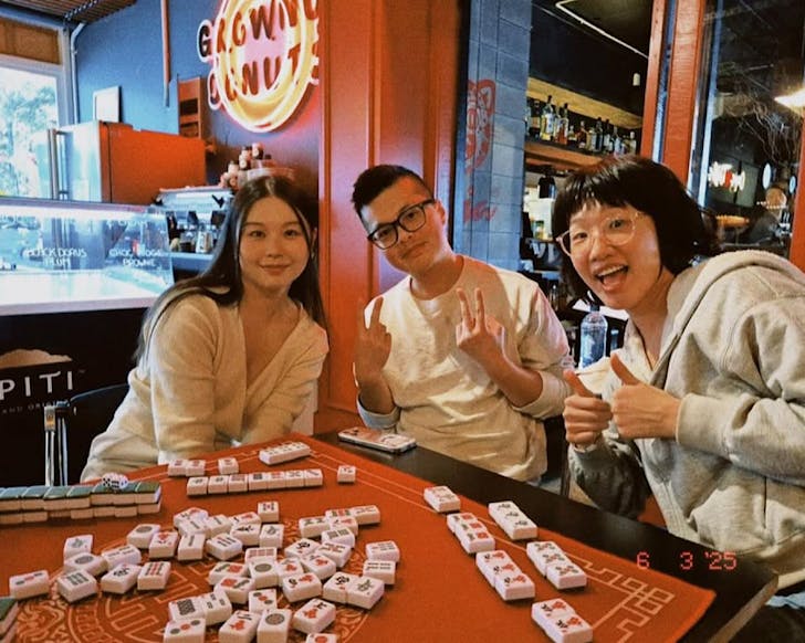 People enjoy a game of social Mahjong at Grown Up Donuts.