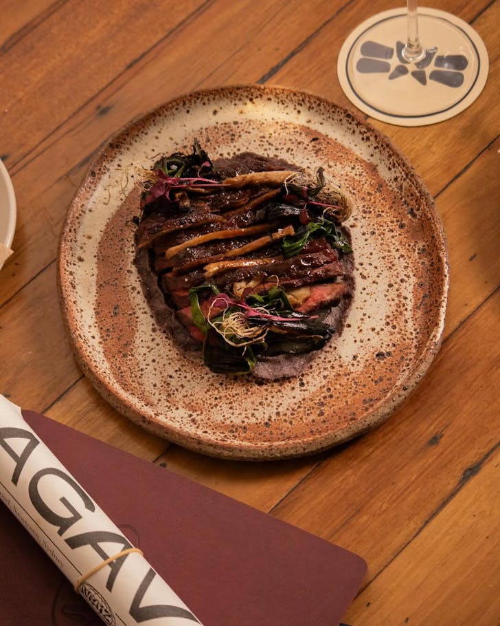 Maiz collaboration with forged by vow, cultivated quail dish plated on a wooden table