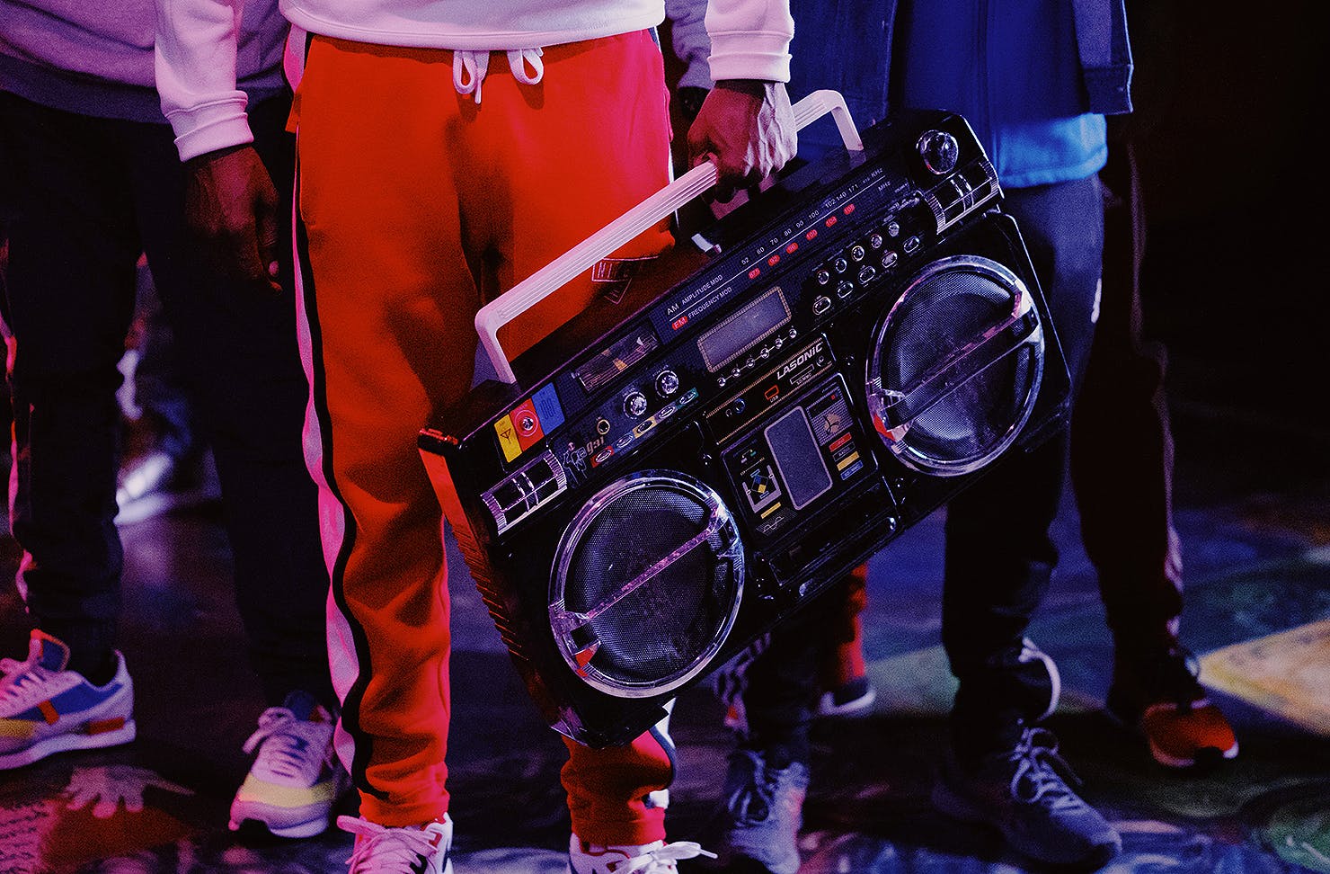 Man in red trackies holds an old school beatbox.