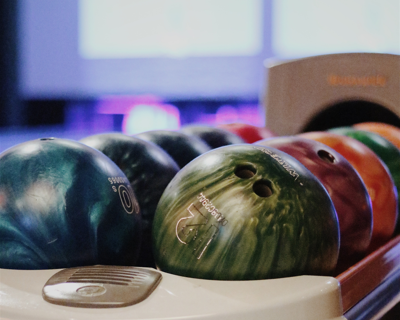 A close-up of the colourful bowling balls waiting to be used