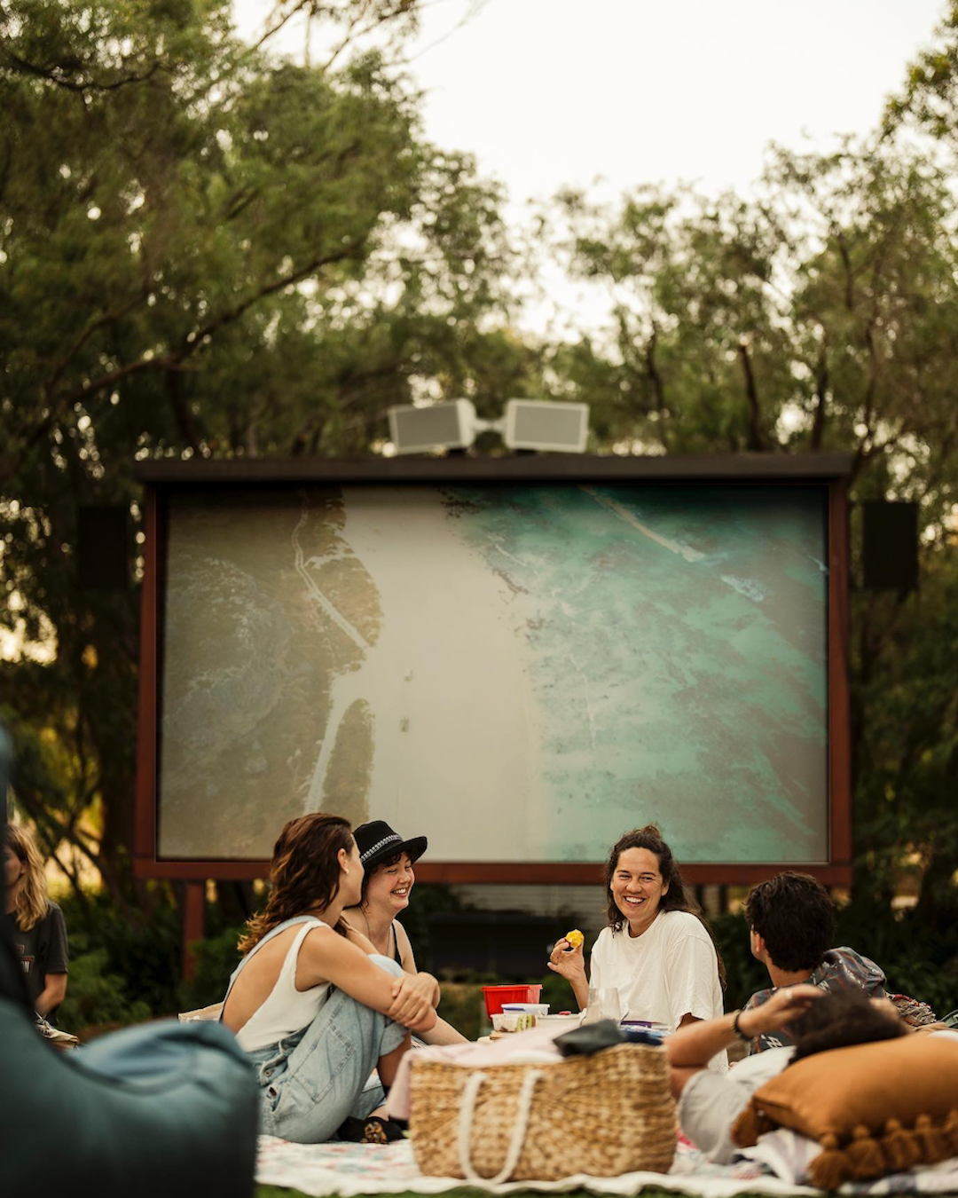 A group of people enjoying an outdoor picnic and outdoor movie at Cape Mentelle winery in Margaret River