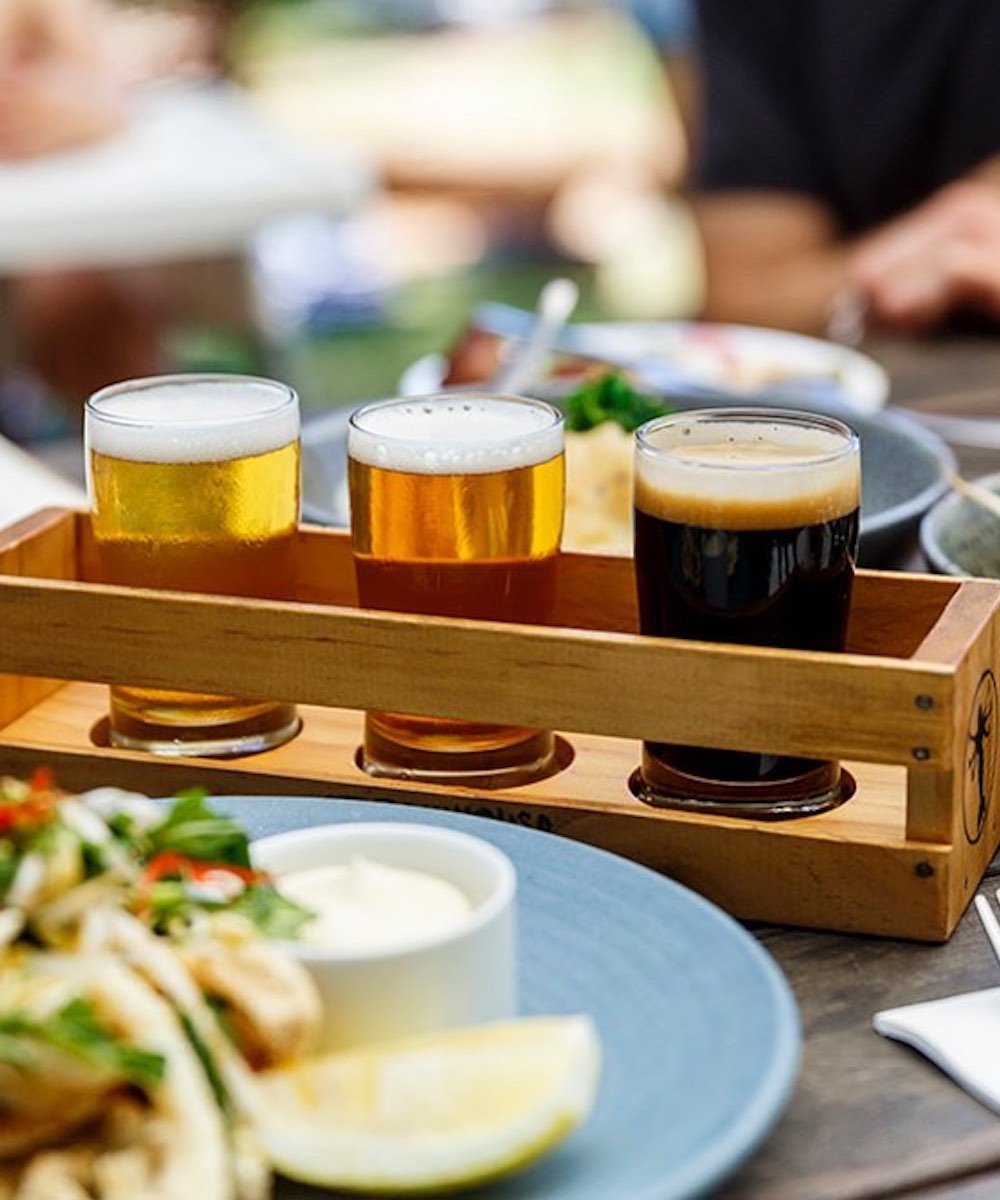 A beer tasting paddled filled with three beers.