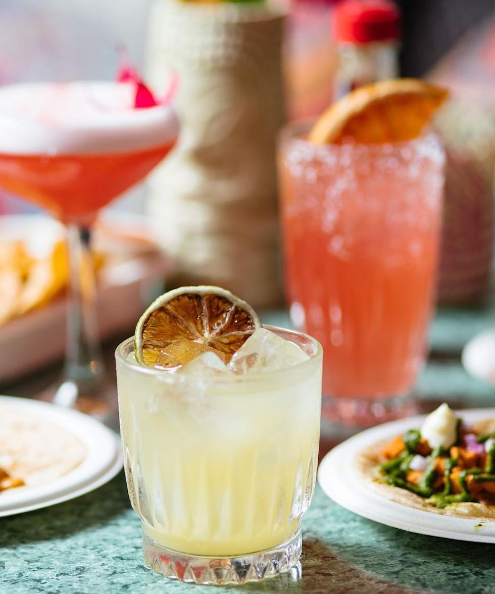 A tommy margarita surrounded by other Mexican food and drinks at Cabalitos