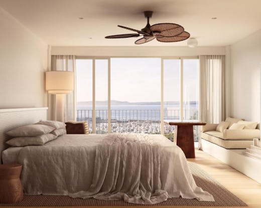 Ocean-view suite at Marina Resort with linen-draped bed, timber accents and floor-to-ceiling windows overlooking Nelson Bay.