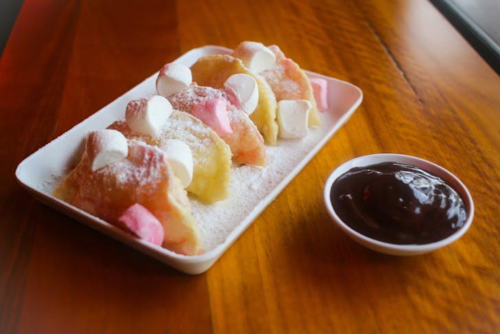 a plate of marshmallow dumping with a small bowl of nutella dipping sauce