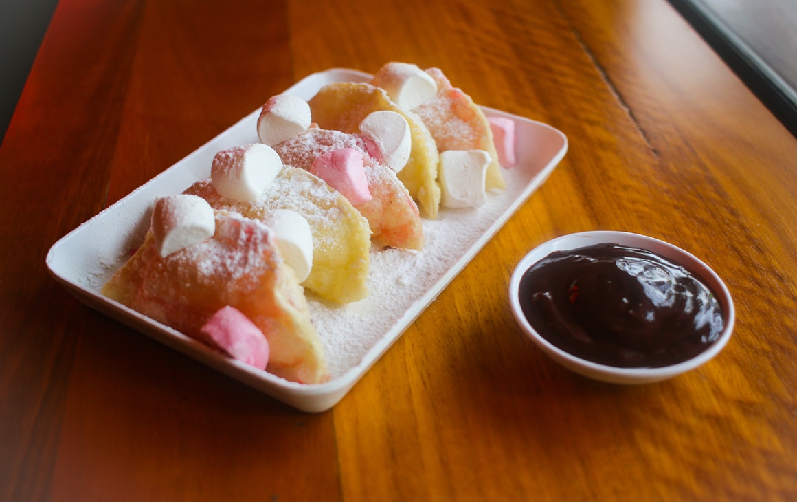 a plate of marshmallow dumping with a small bowl of nutella dipping sauce