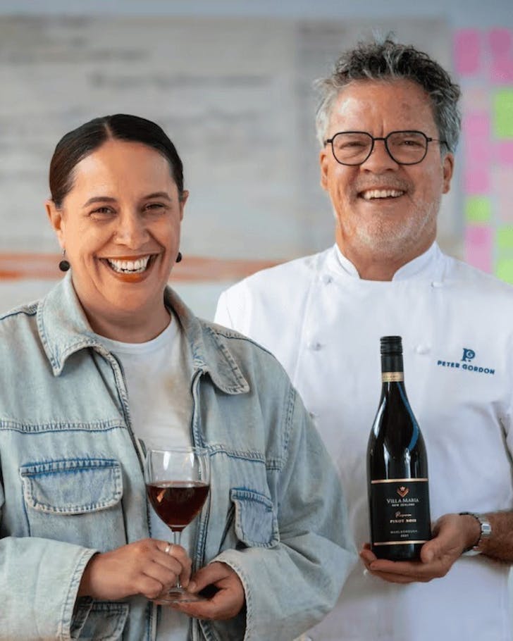 Kura Forester and Peter Gordon pose with a glass of red wine and the bottle respectively.