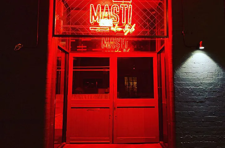 A neon-lit interior with a red neon sign that reads 
