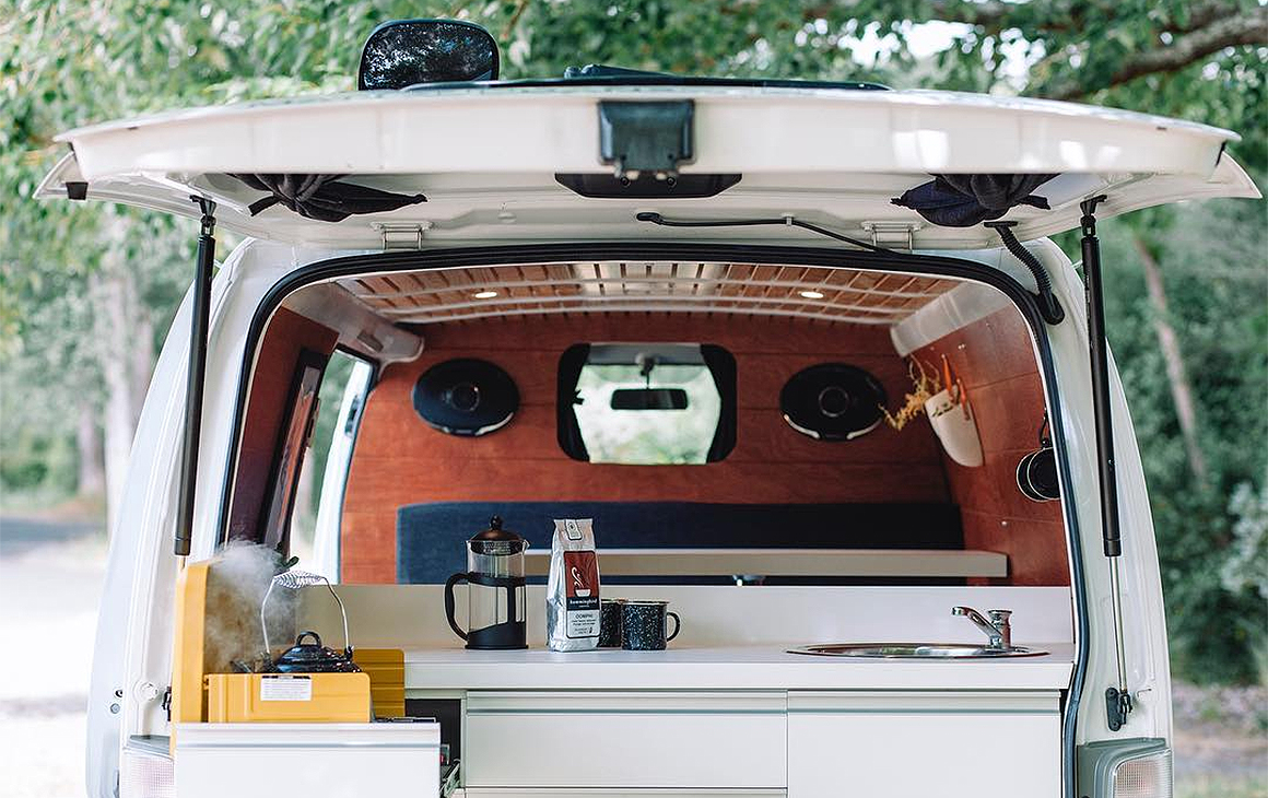 The back view of one of Matt and Dan's campervans showing a sink with a kettle on the boil.