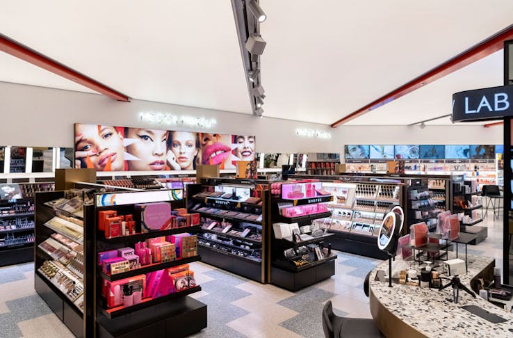 The interior of the Mecca beauty and makeup store, with shelves of makeup products. 