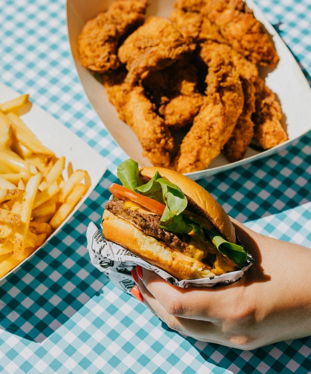 a burger with fried chicken and fries 