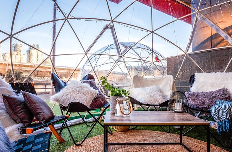 An igloo with chairs and fur rugs. 