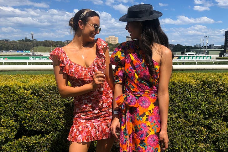 Two women standing in front of a race course