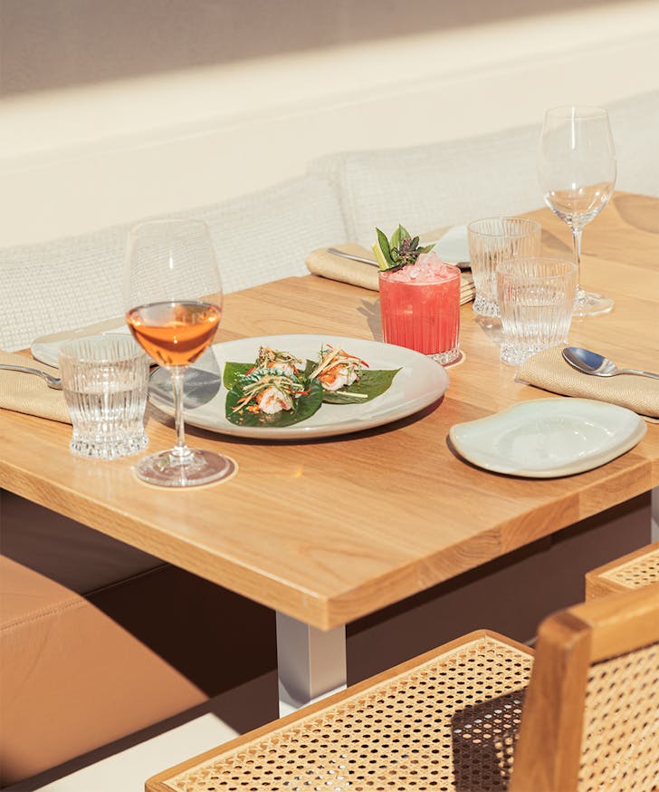 a table with a plate of food and two drinks on it