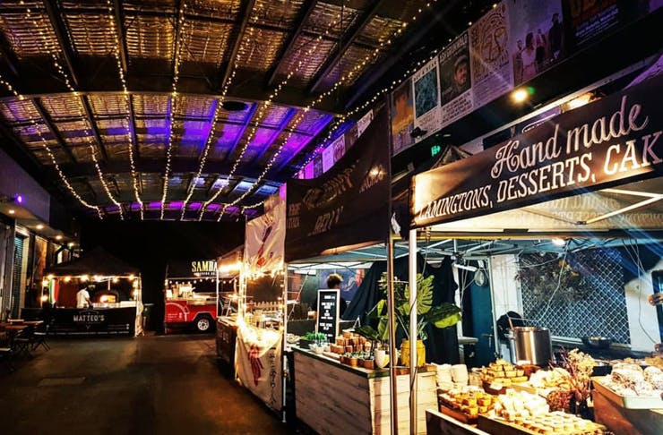 A row of street food stalls inside of Miami Marketta, a night market on the Gold Coast. 