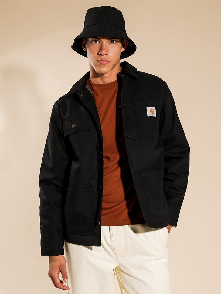 A man in a bucket hat and black Carhartt Chore coat.
