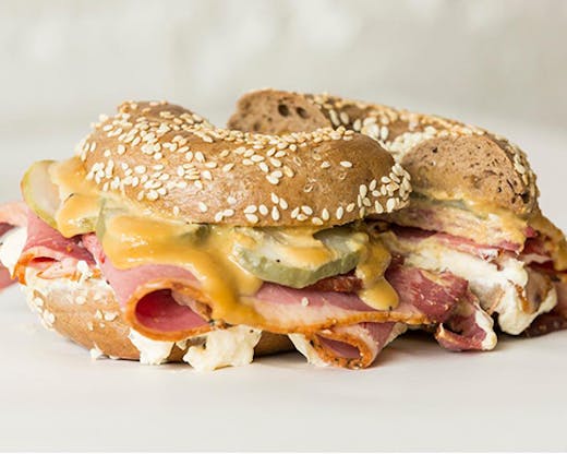 A bagel filled with brisket pastrami and melting cheese.