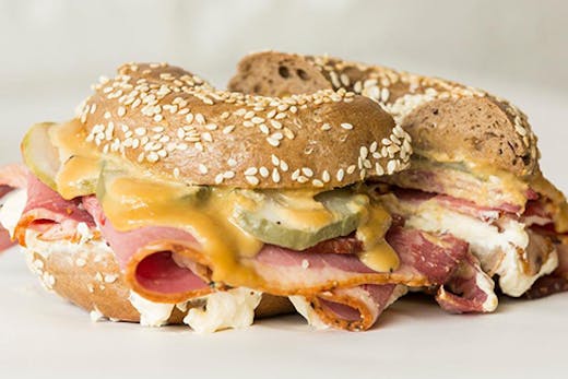 A bagel filled with brisket pastrami and melting cheese.