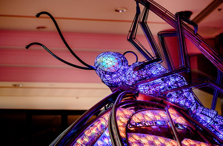 A close-up shot of a purple insect art installation.