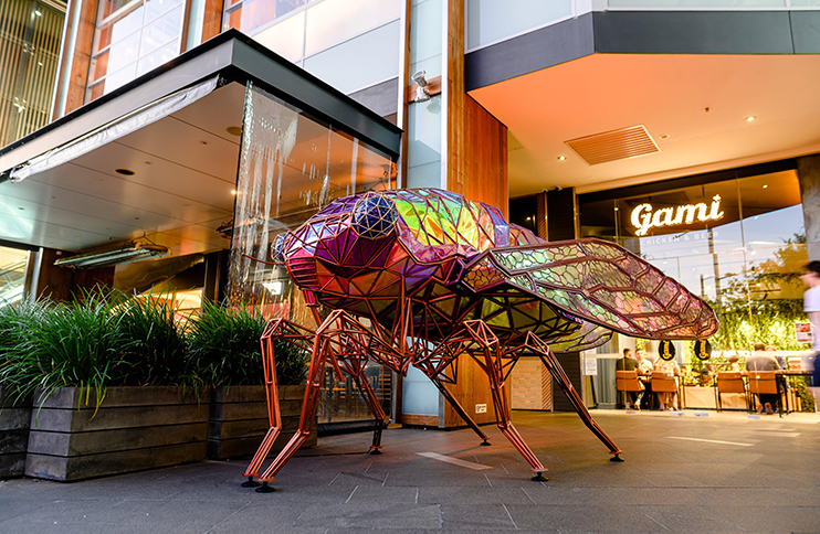 A large colourful insect part of an art installation.