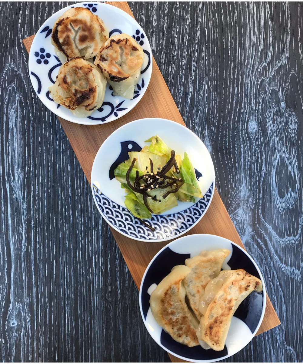 Two plates of gyoza (Japanese dumpling) and a plate of pickles to refresh the palette. 