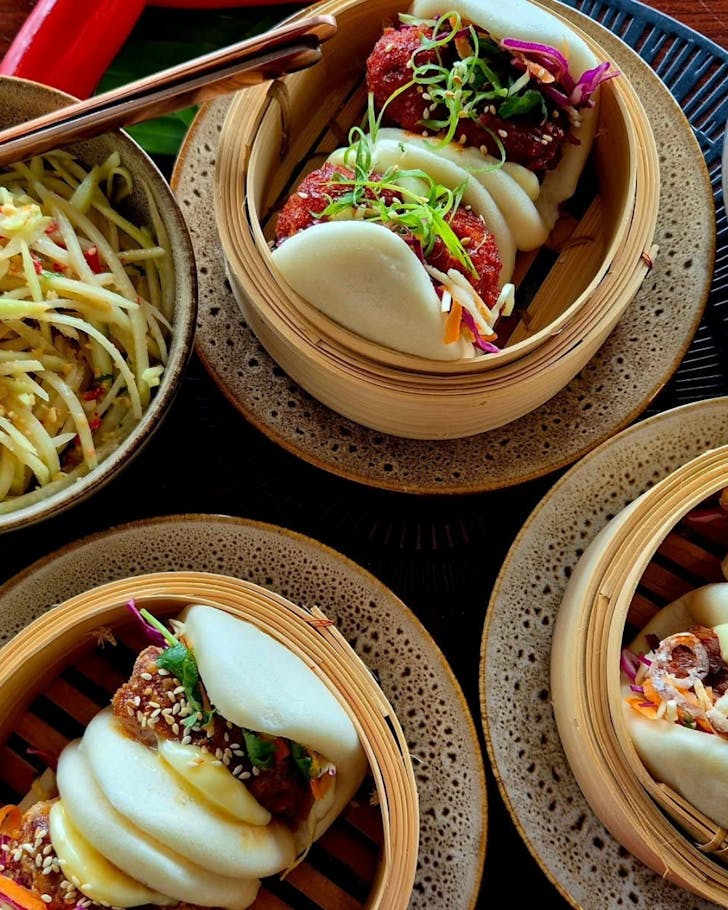 Three bamboo steamers full of delicious bao buns on a table at Miss Chief.