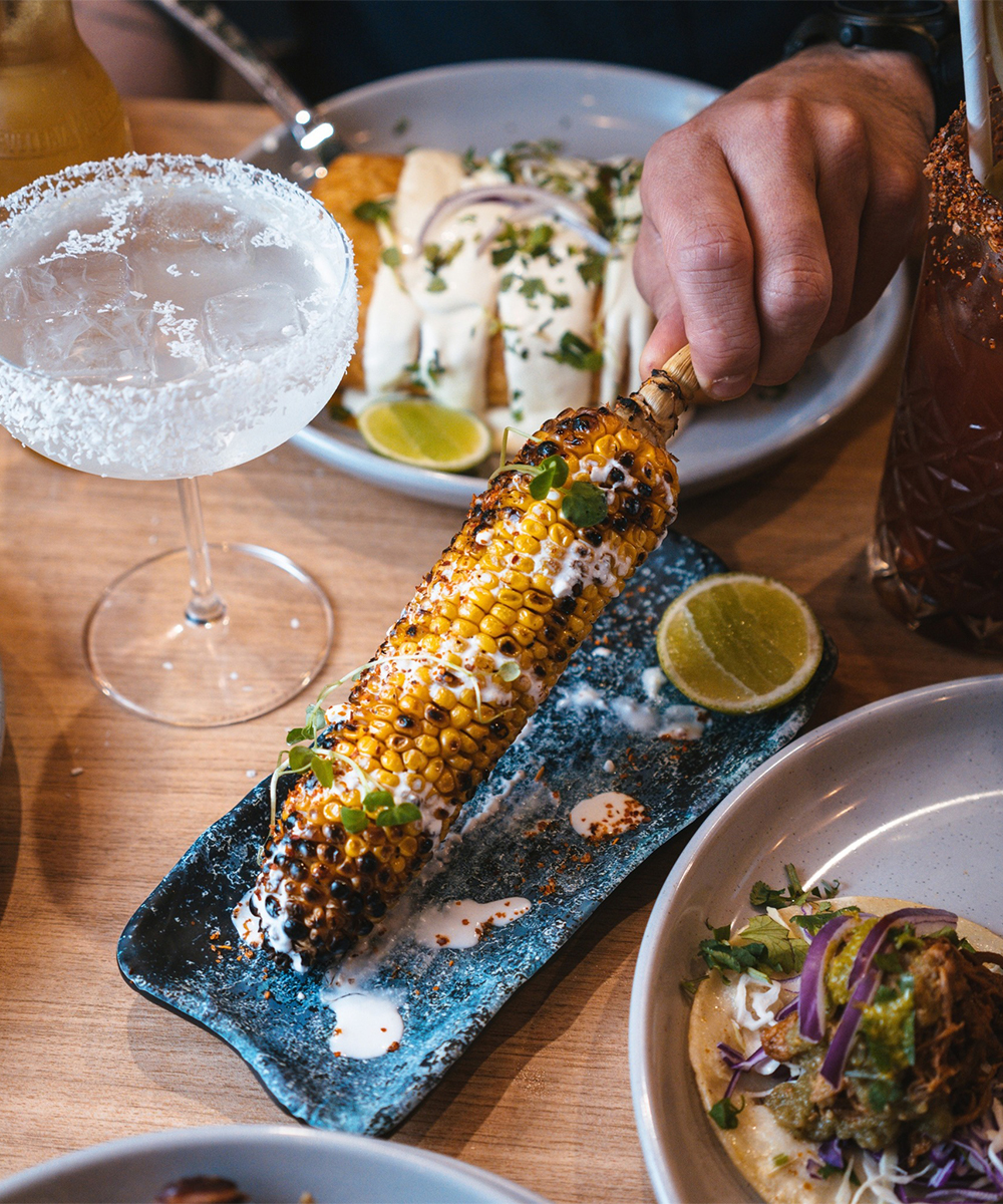 Plate of corn with surrounding dishes