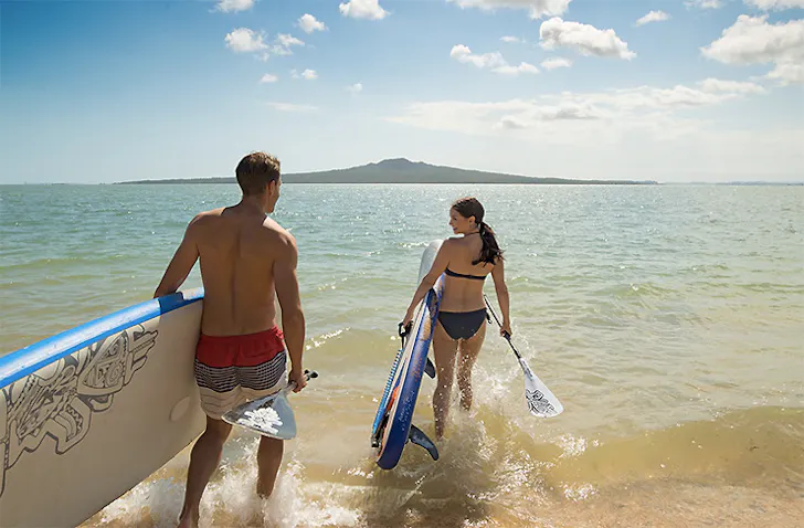 A couple going into the surf, Mission Bay Watersports