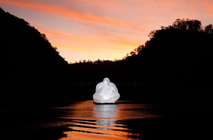An inflatable installation of a man sitting, perched on a lake in Launceston.