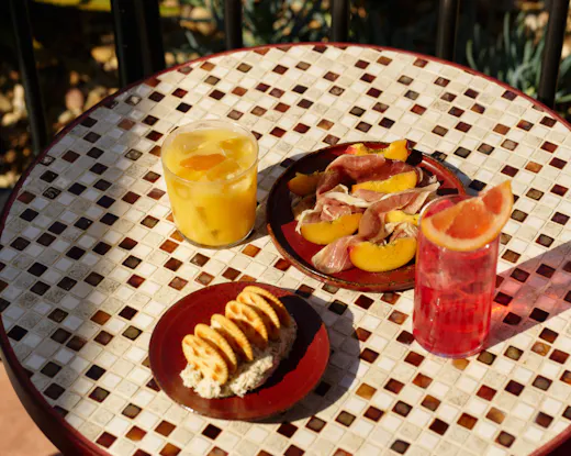 Cocktails and share plates at Monica rooftop, including devilled crab dip, cured meats and sunset-ready drinks served outdoors.