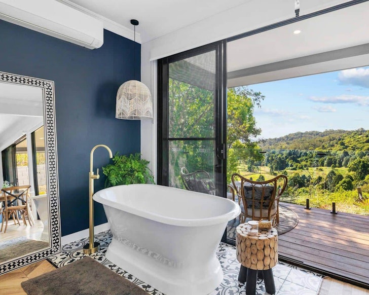 A view of the white bathtub and garden at Fletcher's Ridge Airbnb one of the best accommodation options near Maleny