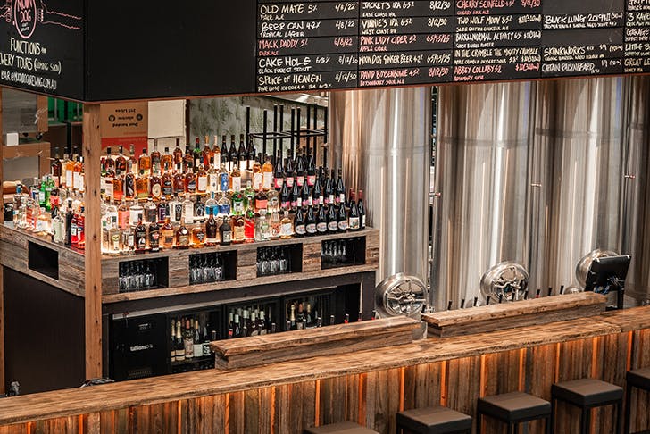 A wooden bar at Moon Dog Brewing stacked with alcohol.