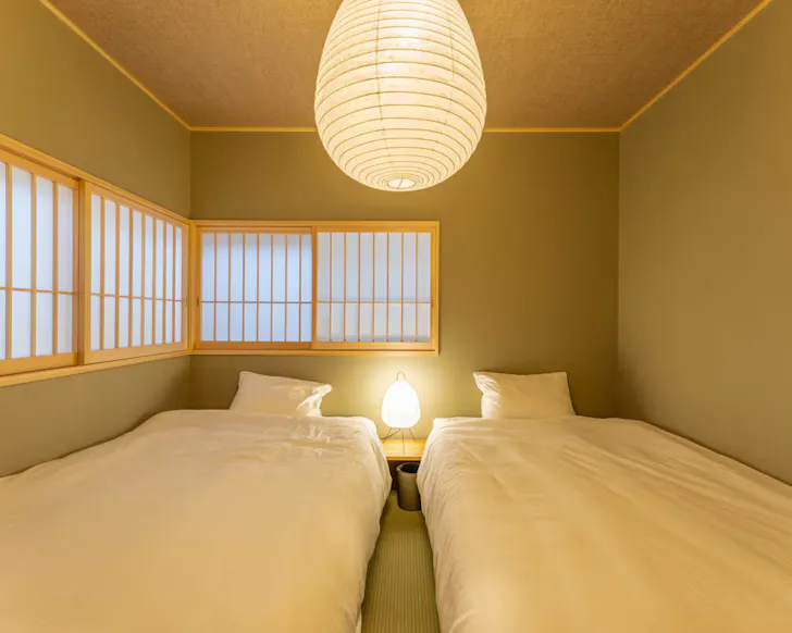 The soothing, sage green bedroom in the moon-view Airbnb in Osaka