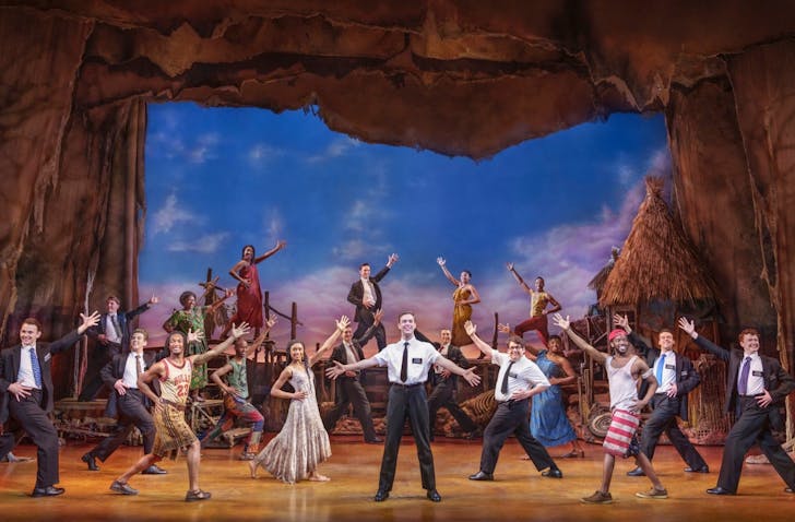 A view of the stage during the Book of Mormon musical. This moment features several mormon boys and several Ugandan locals as they dance with smiles on their faces.