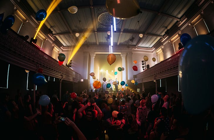 Balloons fly to the ceiling of the gothic St Matthew in the City as morning ravers dance.