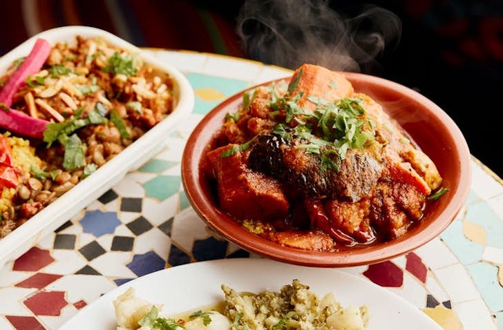 A mosaic-tiled table with different middle eastern restaurant Melbourne dishes. 