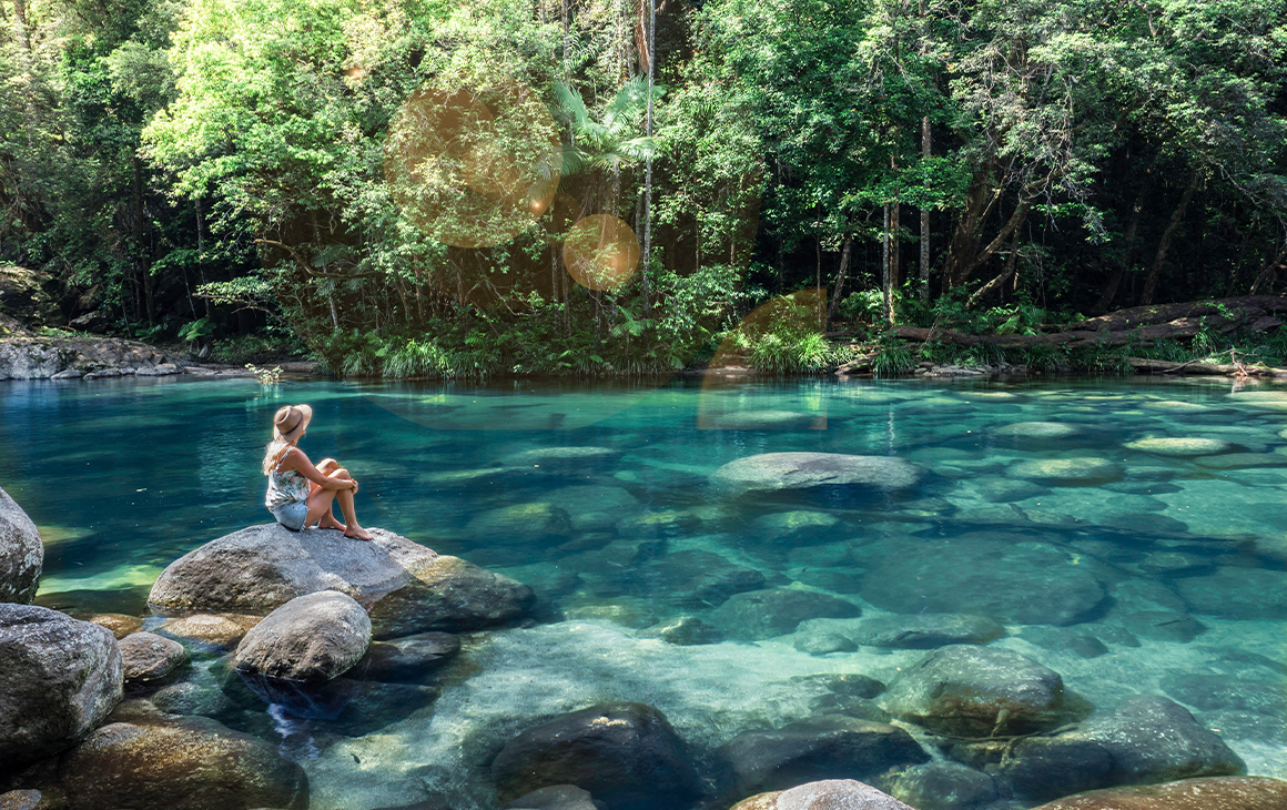 woman sitting by a creek