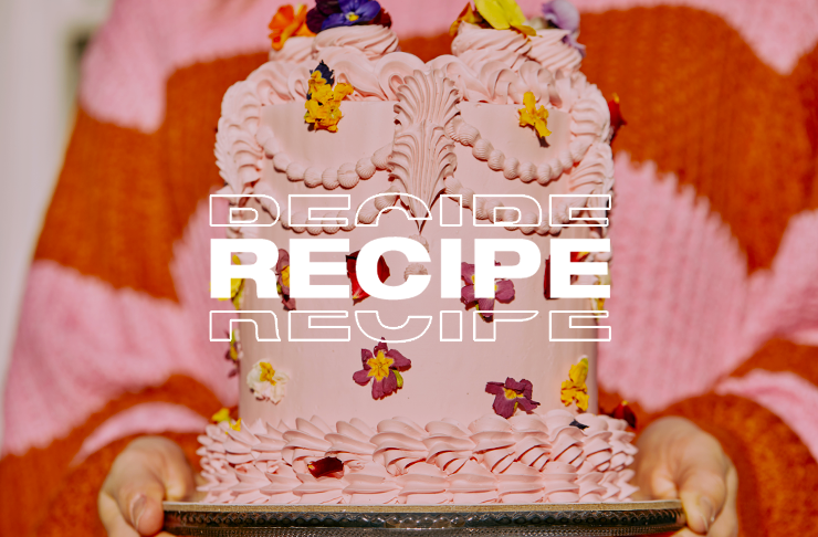 A large pink vintage cake being held in two hands.