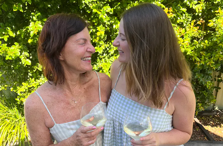 A mother and daughter standing together with wines