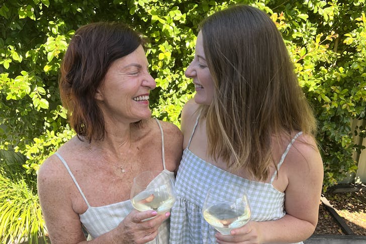A mother and daughter standing together with wines