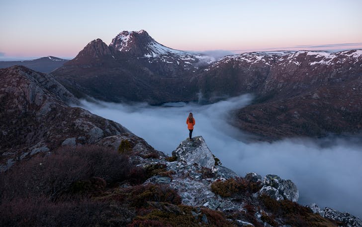 Person standing in mountainous ranges.