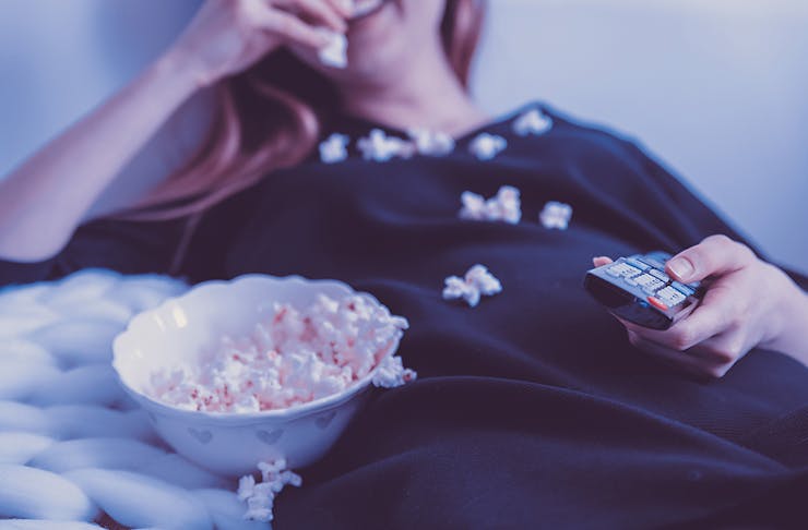 Woman lying on sofa with popcorn