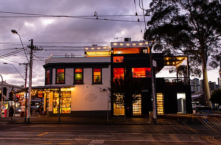 A pub drenched in red lights in the twilight.