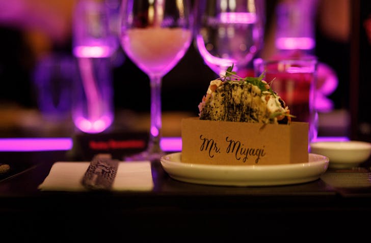A dimly lit bar with cocktails and a taco at a christmas party Melbourne venue.