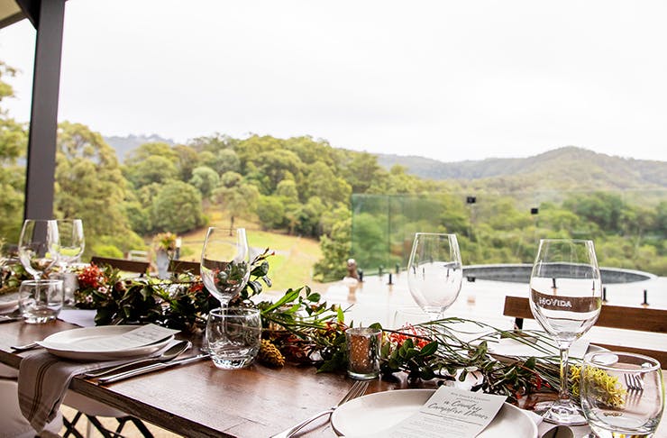 A beautiful long lunch table setting with a picturesque hinterland view in the background.