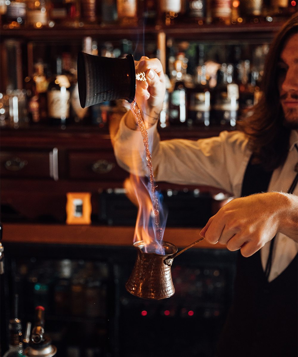 a bartender making a cocktail with fire