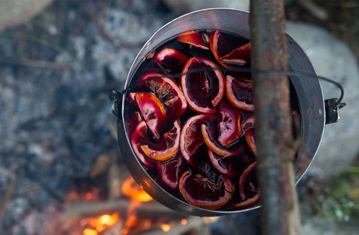 A pot of mulled wine over a campfire.