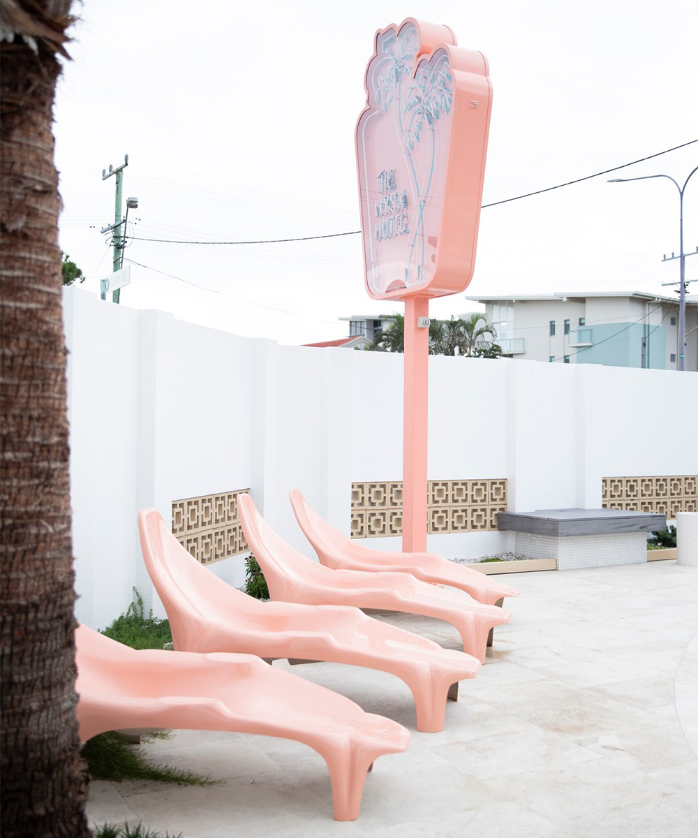 pink pool chairs under a motel sign