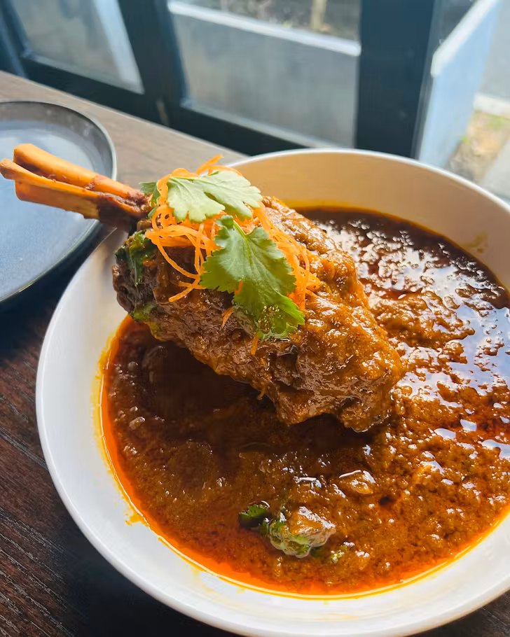 The Lamb shanks in richly spiced sauce with cumin, cardamom, cloves, cinnamon & finished with tomato and onion gravy from Namaste India